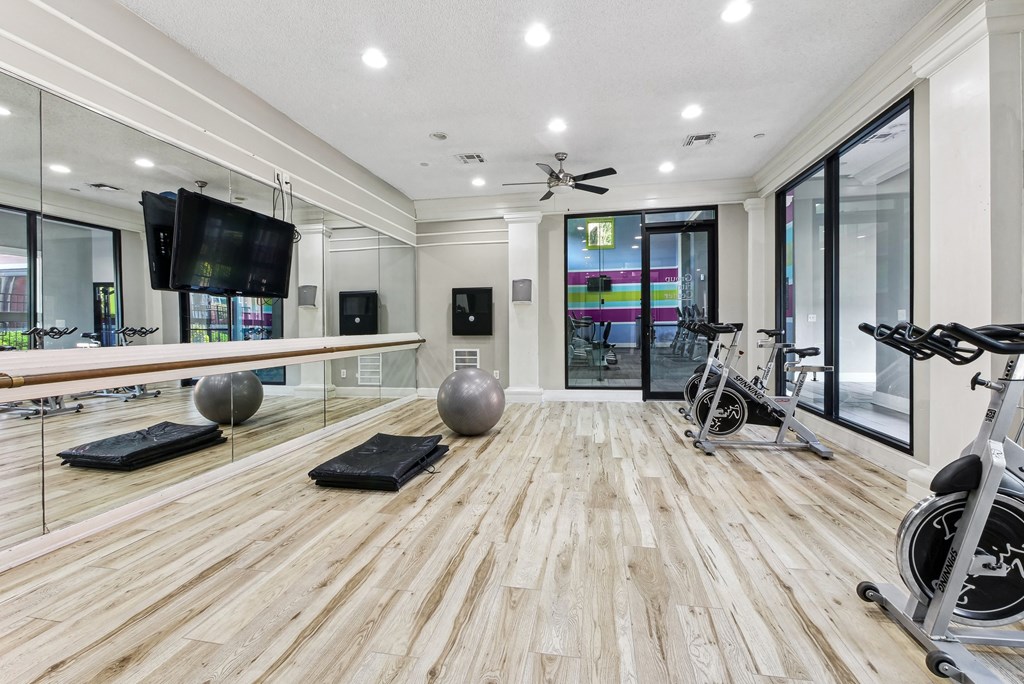 Yoga & Cycling studio A spacious room with wooden flooring and exercise equipment.